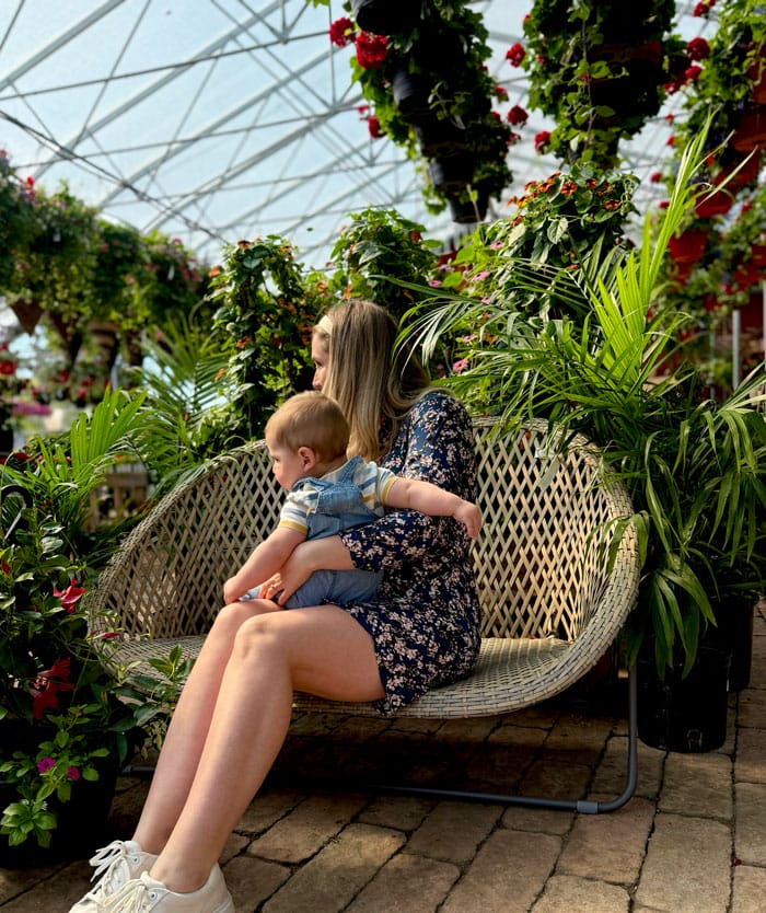 Femme et bébé sur une chaine entouré de fleurs